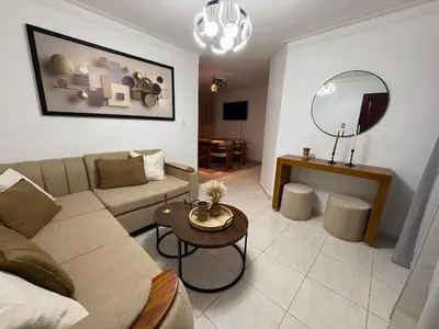 a living room with a couch and a table at Cómodo y moderno apartamento en Santiago Gurabo Sin costo de limpieza in Santiago de los Caballeros
