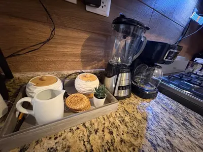 a counter top with a blender and cups on it at Cómodo y moderno apartamento en Santiago Gurabo Sin costo de limpieza in Santiago de los Caballeros