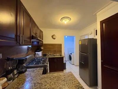 a kitchen with a stainless steel refrigerator and a sink at Cómodo y moderno apartamento en Santiago Gurabo Sin costo de limpieza in Santiago de los Caballeros