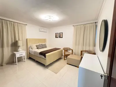a bedroom with a bed and a chair in it at Cómodo y moderno apartamento en Santiago Gurabo Sin costo de limpieza in Santiago de los Caballeros