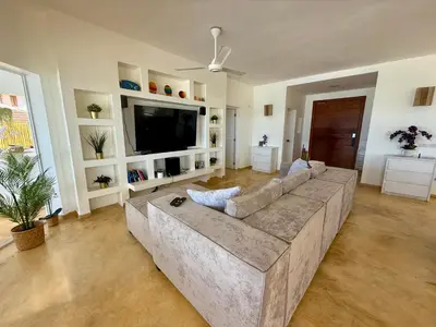 a living room with a large couch and a television at Villa Bella Vista - Luxury Ocean View and Private Pool, Las Terrenas in Las Terrenas