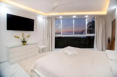 a white bedroom with a large bed and a large window at Villa Bella Vista - Luxury Ocean View and Private Pool, Las Terrenas in Las Terrenas