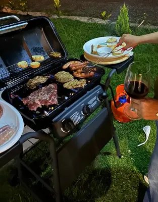 a person cooking food on a grill with a plate of food at La gloria