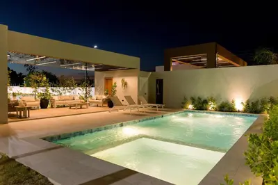 a swimming pool in the backyard of a house at night at Mountain and pool modern apartment in Santiago de los Caballeros