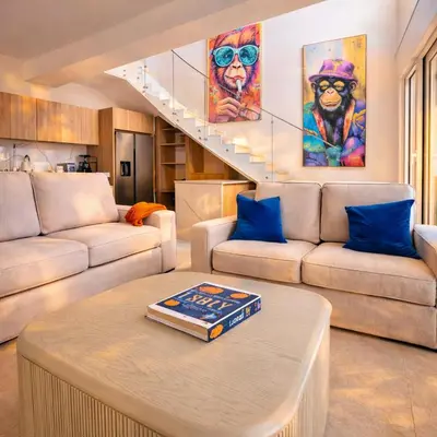 a living room with two couches and a table at Sunset Calm Penthouse in Cabarete