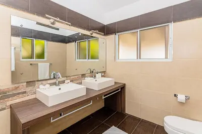 a bathroom with two sinks and a mirror at Villa Ocean Dream 3BR Oasis and guesthouse in Sosúa