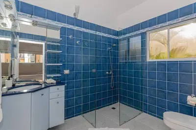 a blue tiled bathroom with a sink and a toilet at Villa Ocean Dream 3BR Oasis and guesthouse in Sosúa
