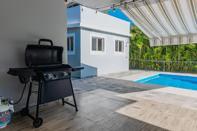 a barbecue grill in a patio with a swimming pool at Villa Ocean Dream 3BR Oasis and guesthouse in Sosúa