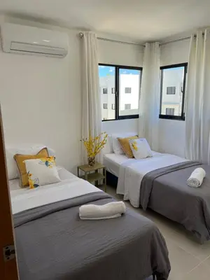 two beds in a room with two windows at Oasis in Graditti valley in Santiago de los Caballeros
