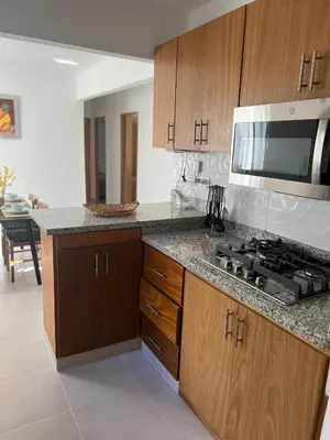 a kitchen with wooden cabinets and a stove top oven at Oasis in Graditti valley in Santiago de los Caballeros