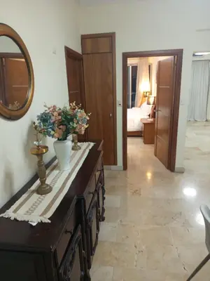 a bathroom with a vanity with a mirror and flowers on it at Torre chalom in Santo Domingo