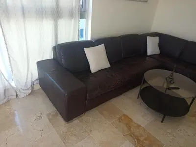 a brown leather couch in a living room with a table at Torre chalom in Santo Domingo