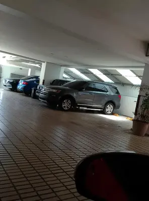 a parking lot with cars parked in a parking garage at Torre chalom in Santo Domingo