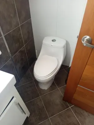 a bathroom with a white toilet in a room at Torre chalom in Santo Domingo