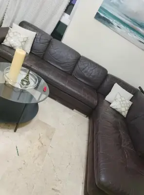 a brown leather couch sitting next to a table at Torre shalom in Santo Domingo