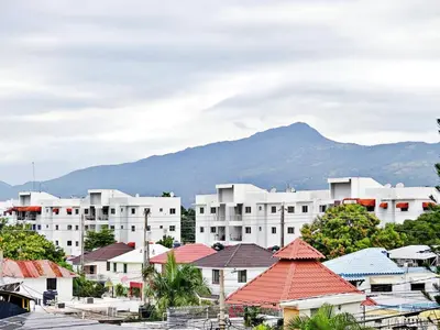 a group of white buildings with a mountain in the background at Padres Las Casa in Santiago de los Caballeros