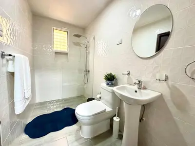 a bathroom with a toilet and a sink and a mirror at Padres Las Casa in Santiago de los Caballeros