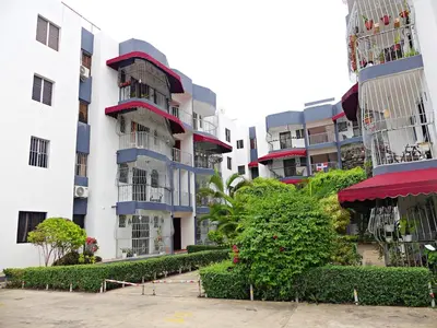 a row of apartment buildings with bushes and trees at Padres Las Casa in Santiago de los Caballeros