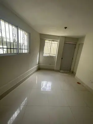 an empty room with two windows and a tiled floor at Bohio rd in Santo Domingo