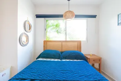 a bedroom with a blue bed with a window at Coastal Corner -Beach-Pool-Terrace-Parking-Pets in Villas del Mar