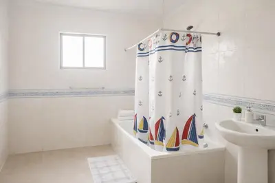 a bathroom with a shower curtain with boats on it at Million View Room Adults Only Resort 2 in La Laguna