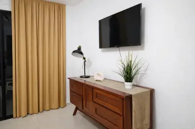a room with a dresser with a television on a wall at Million View Room Adults Only Resort 2 in La Laguna