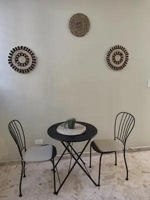 a table and two chairs with a plant on a wall at Comfortable and quiet single room in Santo Domingo