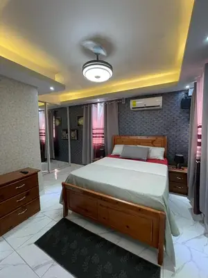 a bedroom with a large bed and a bathroom at Luxury apartment private rooftop & jacuzzi in Santo Domingo