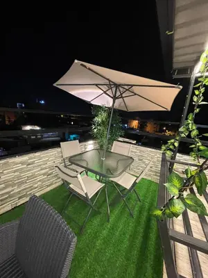 a table and chairs with an umbrella on a balcony at Luxury apartment private rooftop & jacuzzi in Santo Domingo