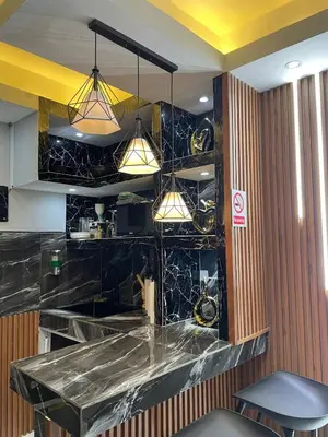 a kitchen with black marble counter tops and lights at Luxury apartment private rooftop & jacuzzi in Santo Domingo