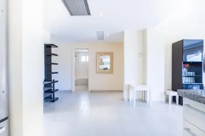 a living room with white walls and a white tile floor at Iberostate 2BR Apartment - BBQ, Terrace, Lake & Golf Views, Beach Club Access in Punta Cana