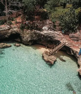 a staircase in a pool of water with rocks at Agapimou apartments H in Gaspar Hernández