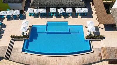 an overhead view of a swimming pool with lounge chairs at Golf View Penthouse with Private Rooftop & BBQ in Punta Cana
