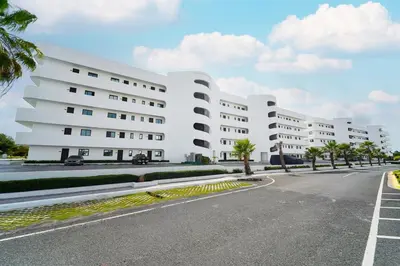 an empty street in front of a white building at Golf View Penthouse with Private Rooftop & BBQ in Punta Cana