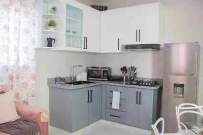 a kitchen with a counter with a microwave and a refrigerator at Apartamentos carrasco in Nagua