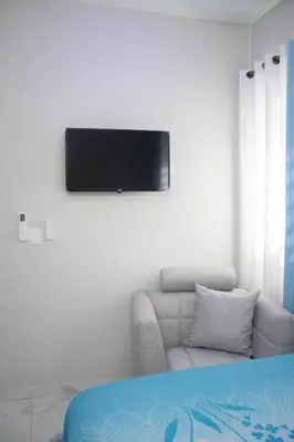 a living room with a couch and a television on a wall at Apartamentos carrasco in Nagua