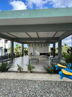 a large covered patio with chairs and tables at Próximo al aeropuerto en santo domingo in La Javilla