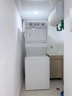 a small kitchen with a white stove and refrigerator at Apartamento en livera RD in Santiago de los Caballeros
