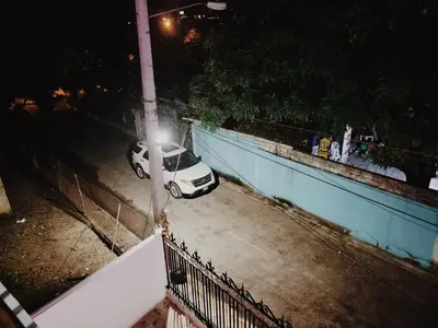 a white car parked next to a fence at night at Hacienda Francisco in Concepción de La Vega