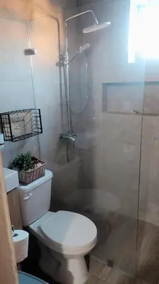 a bathroom with a toilet and a glass shower at El descanso in Higuey
