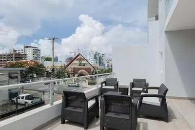 a balcony with a table and chairs and a view of a city at Nestled Comfort in 1BR -WeHost DR in Santo Domingo