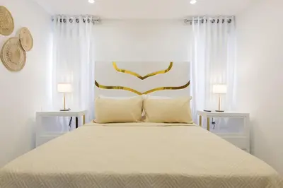 a bedroom with a large bed with two lamps at Nestled Comfort in 1BR -WeHost DR in Santo Domingo
