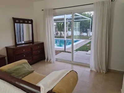 a living room with a sliding glass door to a pool at Oceanfront villa with pool, Ocoa bay in Azua