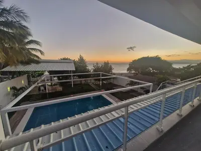a balcony with a swimming pool and a view of the ocean at Oceanfront villa with pool, Ocoa bay in Azua