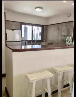 a kitchen with two stools sitting at a bar at Villa exotic in Juan Dolio