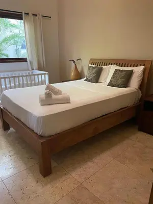 a large bed with a wooden frame in a bedroom at Villa exotic in Juan Dolio