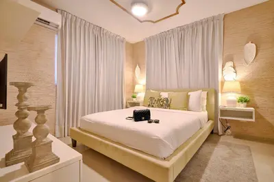 a bedroom with a large white bed with a bag on it at ®{The-Comfty-Spot} Experience @SD WiFi in Santo Domingo