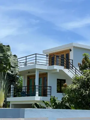 a large white house with a balcony at Monte y Cielo 1 apartment in Las Galeras