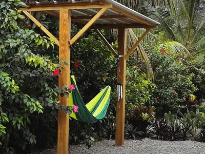 a hammock in a wooden pergola in a garden at Monte y Cielo 1 apartment in Las Galeras