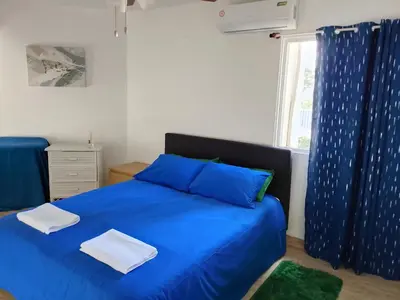 a bedroom with a blue bed and a window at Residencias Turísticas Espinosa in Villas del Mar